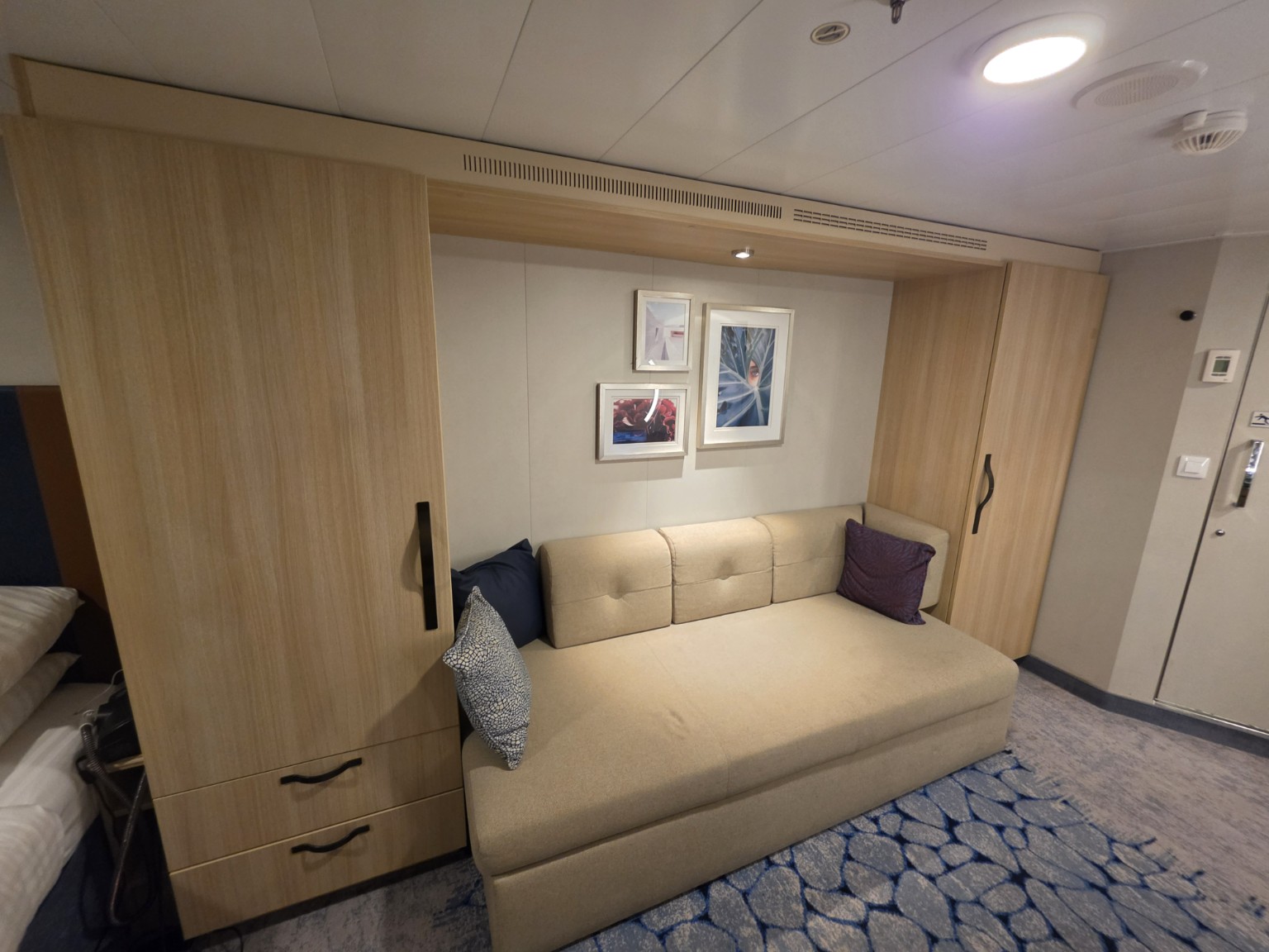 Sofa and built-in storage in our Wonder of the Seas balcony cabin.
