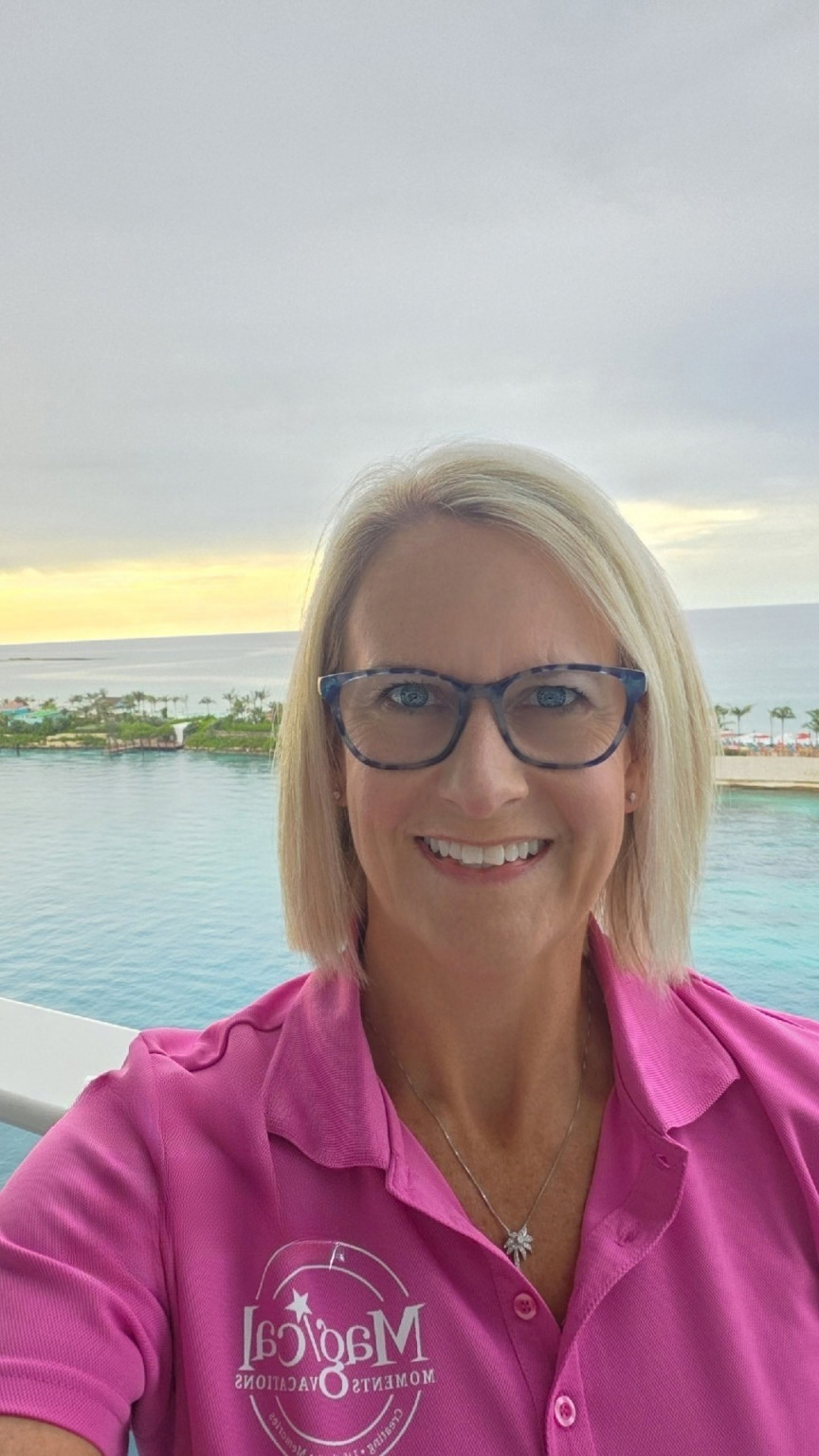 Diana Bertrand smiling on a balcony overlooking turquoise water.